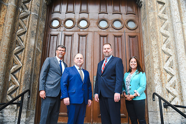Executives from Catholic United Financial and Trusted Fraternal Life stand on the steps of Church of the Assumption in Saint Paul, Minn., the site where Catholic Untied Financial was founded in 1878.